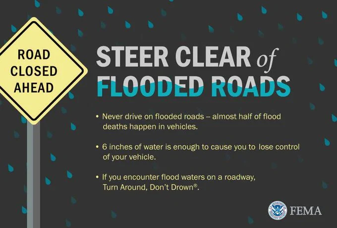 This is a flood safety graphic titled with tips on how to stay safe while driving during floods. The text reads as follows: Steer Clear of Flooded Roads. Never drive through flooded roads - almost half of flood deaths happen in vehicles. 6 inches of water is enough to cause you to lose control of your vehicle. If you encounter flood waters on a roadway, Turn Around, Don't Drown.