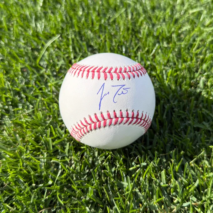 A baseball autographed by J.T. Realmuto in the grass at Citizens Bank Park.